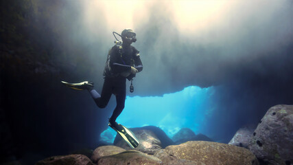 Wall Mural - Scuba diver inside a cave with magic light