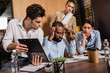 © LIGHTFIELD STUDIOS - thoughtful interracial business people working with documents during meeting