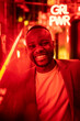 © VICTOR TORRES/Stocksy - Happy black man with neon red light during a club party