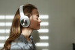 © Danil Nevsky/Stocksy - Woman listening to music in headphones at home