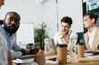 © LIGHTFIELD STUDIOS - young businessman thinking near laptop and blurred interracial friends