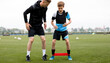 Teenage Boy With Soccer Coach on Stretching Session. Young Football Player Training With Stretching Bands. Workout Stretching Bands