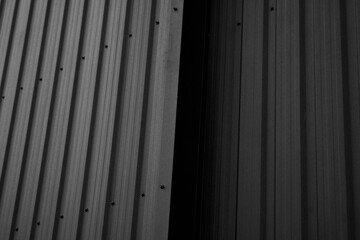 Wall Mural - Black corrugated iron sheet used as a facade of a warehouse or factory. Texture of a seamless corrugated zinc sheet metal aluminum facade. Architecture. Metal texture.