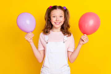 Poster - Portrait of attractive cheerful girl holding balls decor festal event organization isolated over bright yellow color background