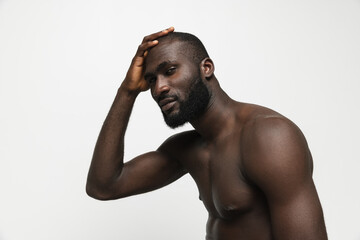 Young handsome muscled African man posing isolated over white background. Concept of beauty, cosmetics, spa.