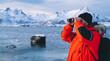 North explorer with binoculars on frozen coast