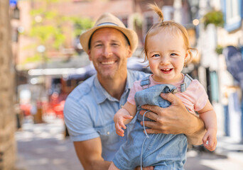 Wall Mural - Young father on street with tiny daughter girl