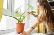 © Ivan Ozerov/Stocksy - Young woman watering plant at home