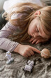 © Lexia Frank/Stocksy - little girl plays with space toys laying down 3