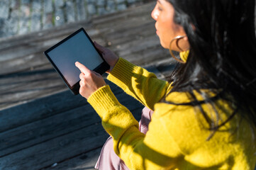 Crop brunette  woman  browsing e-book in city 