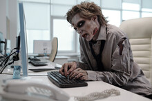 Ugly Man With Zombie Makeup Working With Computer In Office