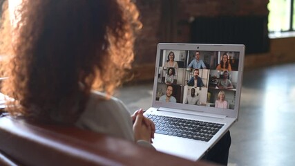 Wall Mural - Red-haired curly woman sitting at the laptop, chatting with friends or colleagues via video meeting, discussing the new project, teaching online,making video call to group of diverse people