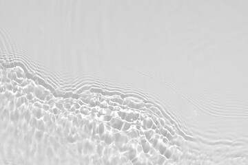 Wall Mural - Desaturated transparent clear calm water surface texture with ripples, splashes Abstract nature background. White-grey water waves in sunlight Copy space Cosmetic moisturizer micellar toner emulsion