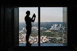 © Alina Hvostikova/Stocksy - Unrecognizable traveler shooting city from hotel window