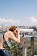 © Alina Hvostikova/Stocksy - Male tourist admiring city through binoculars