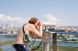 © Alina Hvostikova/Stocksy - Male tourist admiring city through binoculars