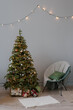 © Alina Hvostikova/Stocksy - Comfortable chair near Christmas tree at home