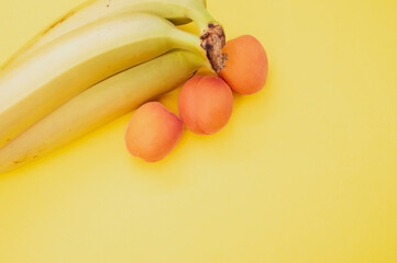 Sticker - High angle shot of ripe bananas and apricots isolated on yellow background