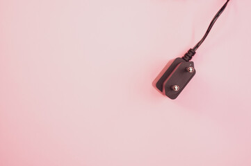 Wall Mural - Top view of wired charger adapter isolated on pink background