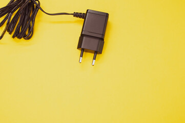 Canvas Print - Top view of wired charger adapter isolated on yellow background