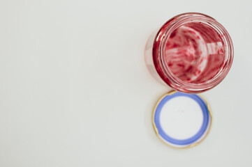 Sticker - Top view of an open empty strawberry jam jar with lid isolated on light gray background