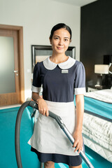 Poster - Beautiful chambermaid with vacuum cleaner looking at you
