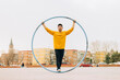 © VICTOR TORRES/Stocksy - Young man performing in the street with a CYR Wheel