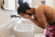 © Michela Ravasio/Stocksy - Guy in the bathroom during morning cleaning