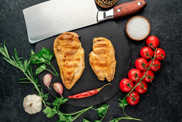 two grilled chicken breasts on a stone background