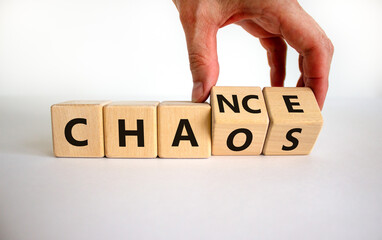 chance or chaos symbol. businessman turns wooden cubes and changes the word 'chaos' to 'chance'. bea