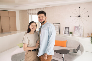 Poster - Happy young couple standing in front of camera in living-room