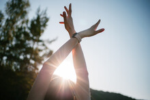 Young Woman Rises Hands Toward The Sun