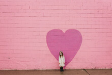 Environmental Portrait Of Little Girl In Mask In Front Of Pink Wall