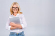 © denis_vermenko - Image of cheerful mature business woman standing isolated over white background using laptop computer. Portrait of a smiling senior lady holding laptop computer.
