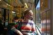 Woman wearing face mask while traveling on public transport