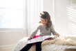 © Lauren Lee/Stocksy - Little girl reading in her room