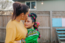 Portrait Mother Kissing Daughter Wearing Traditional Mexican Dress By Fair Lights