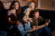 © alfa27 - people enjoying of playing in video game. friends have fun during game , excited millennial diverse american friends have fun with joysticks in living room interior