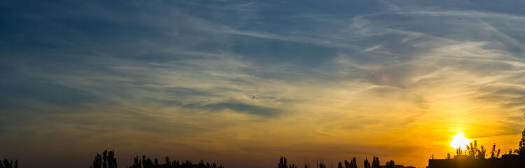 Wall Mural - Landscape with dramatic light - beautiful golden sunset with saturated sky and clouds.