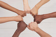 Multiethnic people holding hands in a circle together, multiethnic business team promising help and support, close-up, top view