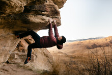 A Climber Hangs From A Rock