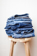 © Anna Tabakova/Stocksy - Stack of denim on a chair