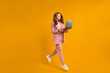 © alfa27 - Happy jumping woman with laptop isolated on yellow studio background. Modern technologies, freedom of choices concept, emotions concept. Using laptop for work and fun in flight.