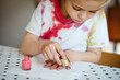 © Melissa Milis Photography/Stocksy - Toddler boy putting on pink nailpolish