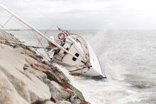 Wrecked Sailboat At The Coast With Waves Impact
