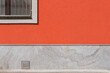 © Alessandra Desole/Stocksy - red wall and window on minimal street view