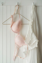 Pink Lace Bras With Nightgown Hanging On Hooks 