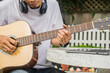 © Suriyo - man learning to play guitar online at home
