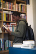 © Ani Dimi/Stocksy - Student taking a book from the shelf in the library