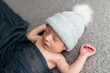 © Alison Winterroth/Stocksy - A baby on grey in a cute hat